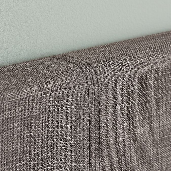 close up zoomed in image of grey fabric of single bed's headboard