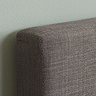 close up image of grey fabric of single bed's headboard