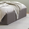 close up image on bottom half of grey fabric storage bed