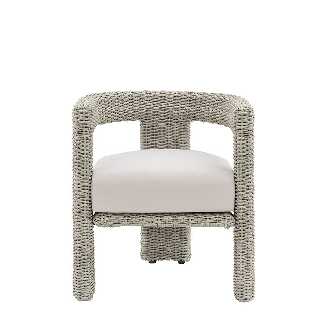 front on image cut out on white background of wicker round backed dining chair with plush cream cushion