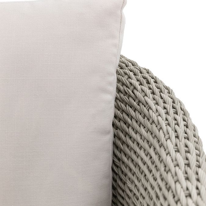 close up image of grey wicker garden chair with plush cream back cushion