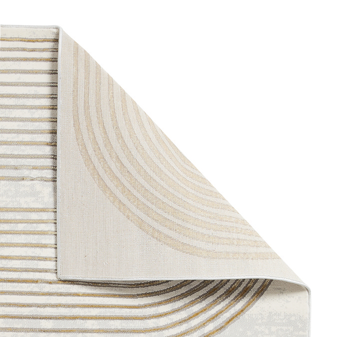 image cut out on white background of gold-patterned grey rug, with corner folded over to show floor-facing material