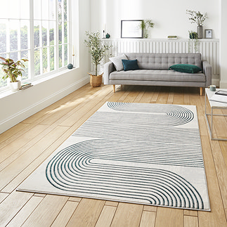 image of large rectangular grey rug with green geometric swirl pattern in middle of loft apartment