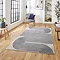 image of large grey rectangular rug with navy swirl geometric pattern on wooden floor in modern loft apartment