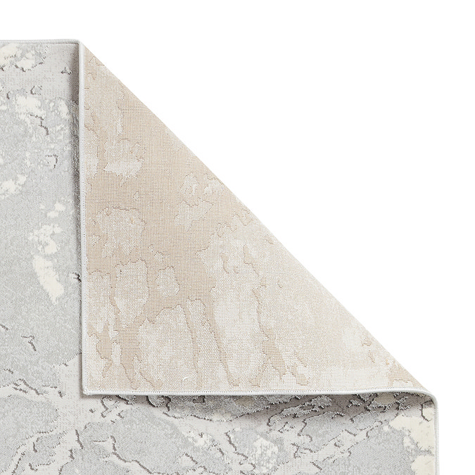 image cut out on white background of rug with corner folded over to show floor-facing material