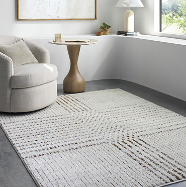 close up image of cream rug with brown lines, folded up at the corner to show material underneath
