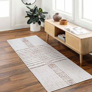 image of ivory and brown striped runner on dark wood flooring of a home office in front of a console table