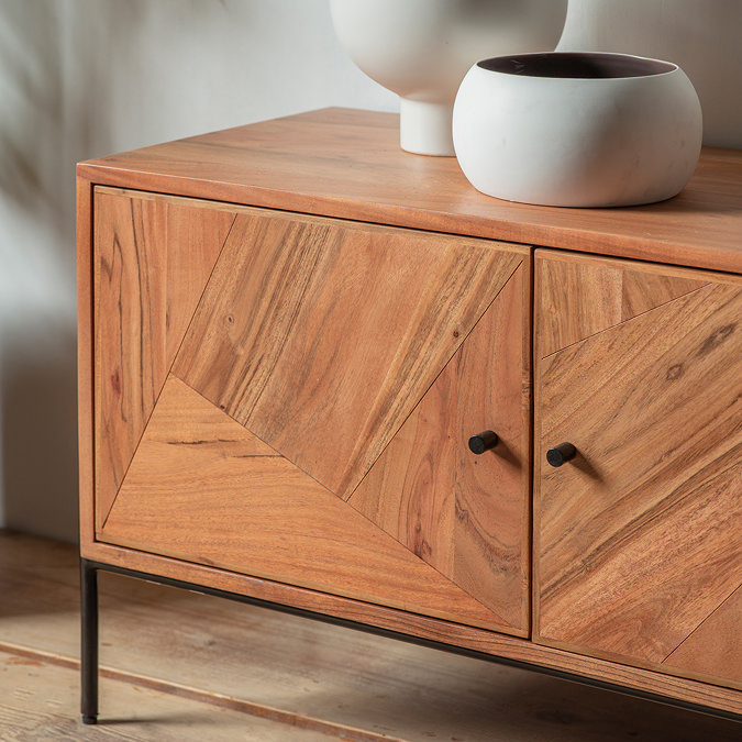close up image on acacia wood construction of tv unit with black iron legs and handles