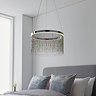 image of chrome tasselled pendant light hanging over grey bed