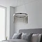 image of chrome tasselled pendant light hanging over grey bed
