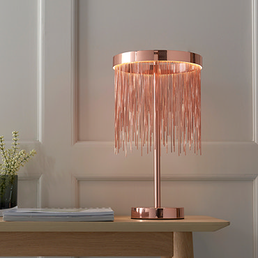 image of brushed copper fringe tasselled table lamp on a bedside table