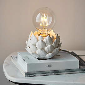 image of round lamp base with artichoke texture in oatmeal colour, on top of a pile of white books