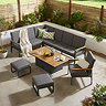 image taken from slightly above of grey corner lounge set with teak arms, matching chair and two stools, around a rectangular coffee table with lifting slatted tabletop