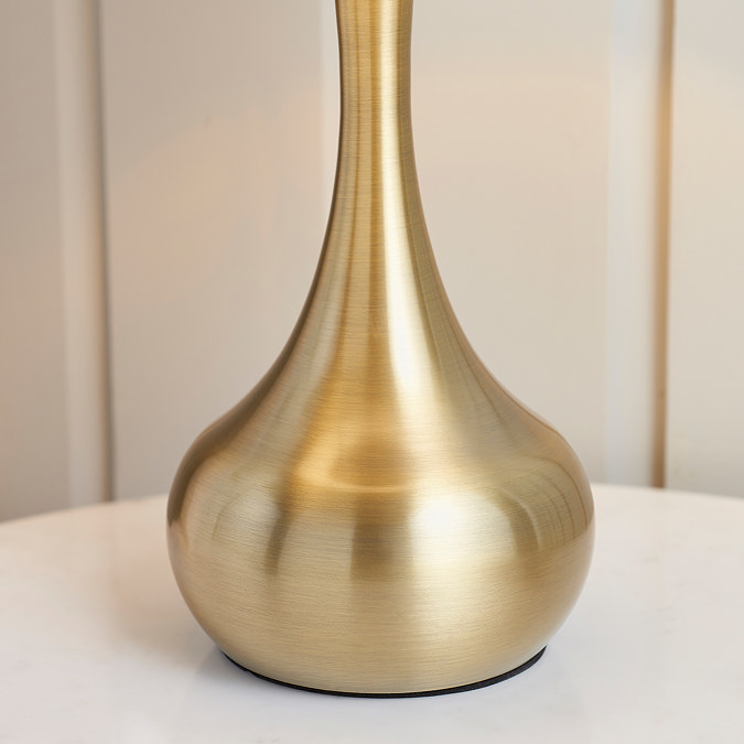 close up on brass body of table lamp on a bedroom side table