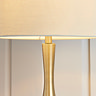 close up on middle of table lamp where linen shade meets brass body