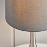 close up image of linen shade of nickel and grey table lamp