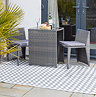 image of slate grey zig-zag patterned outdoor rug under grey rattan dining set outside conservatory windows