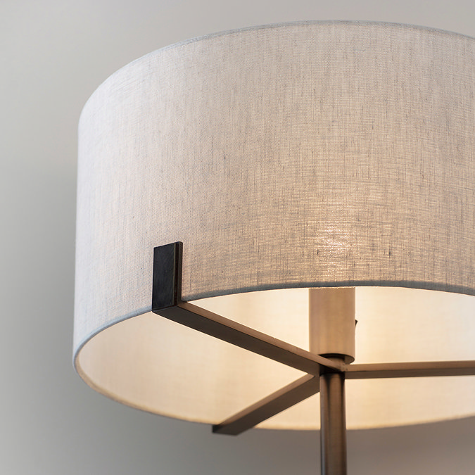 close up image of natural linen shade of floor lamp with dark bronze body