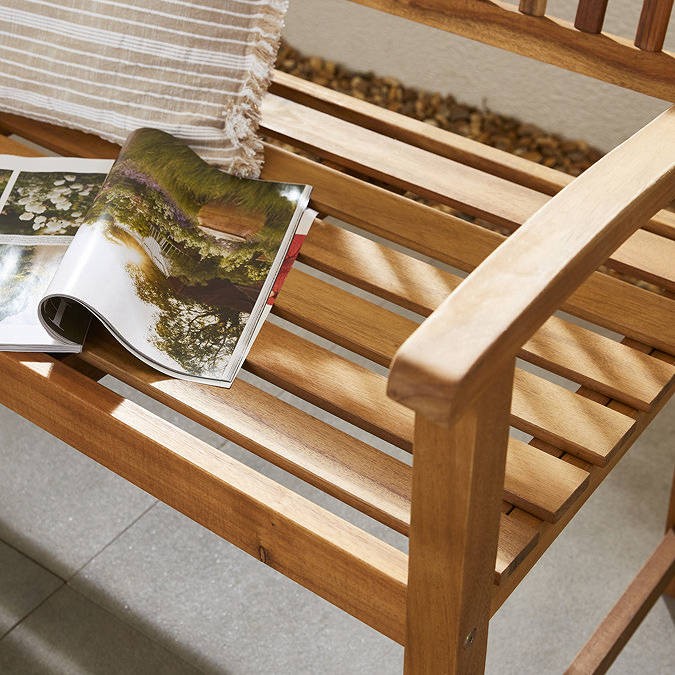 close up image of wooden oil teak bench, with magazine open on it