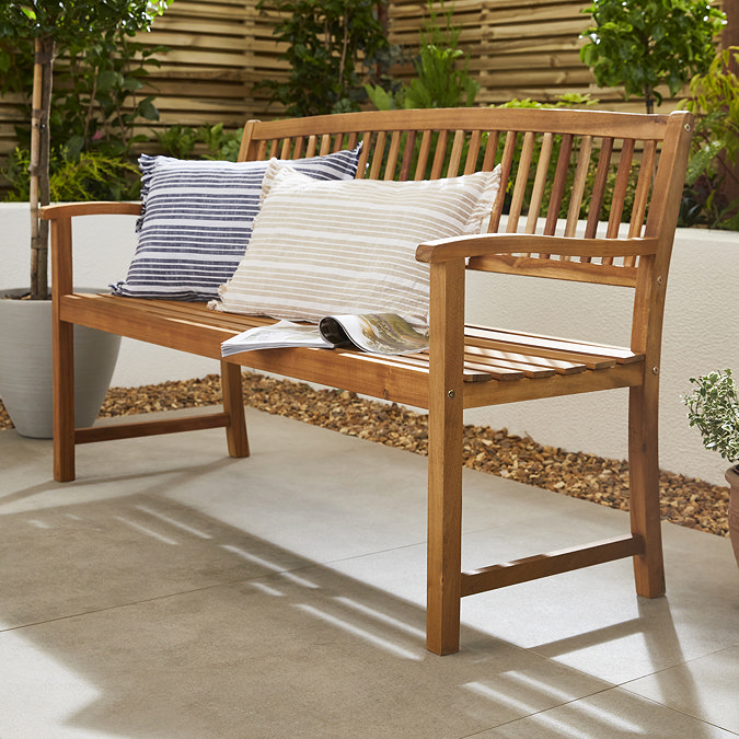 side on image of three seat bench with two cushions out in garden