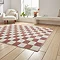 angled image of checkerboard rug in plum and cream on light wooden floor