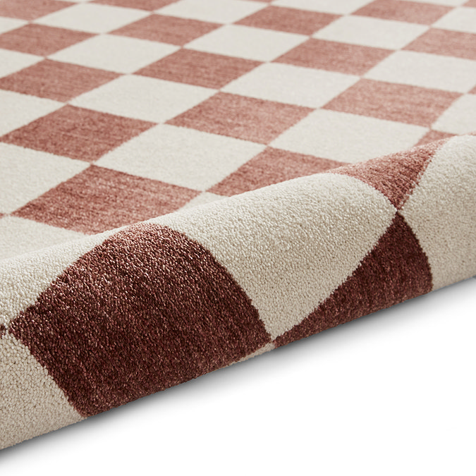image of plum and cream rug rolled up at the end
