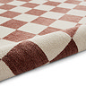 image of plum and cream rug rolled up at the end