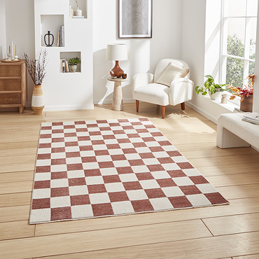 angled image of checkerboard rug in plum and cream on light wooden floor