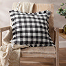 barton gingham check cushion in black and cream, on an accent chair with cream throw