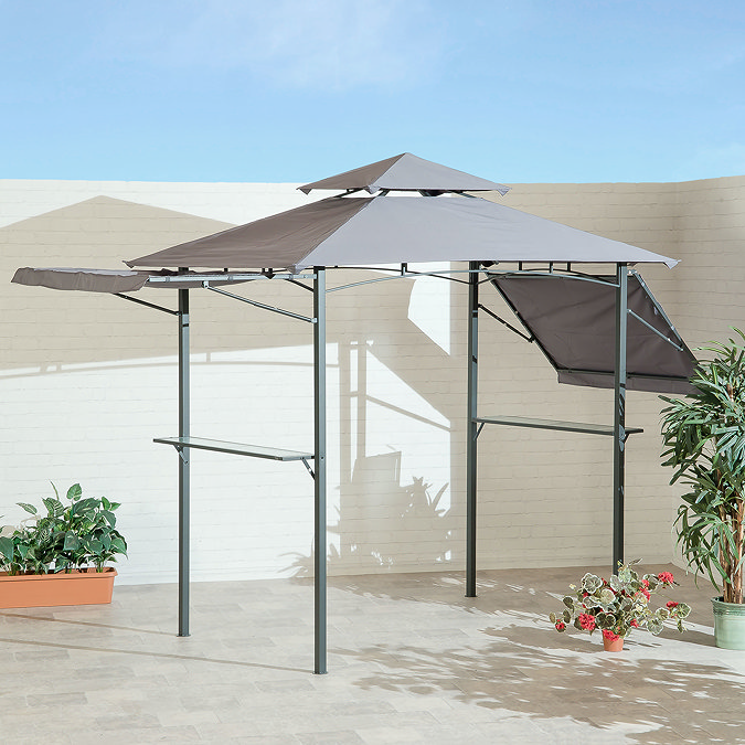 image of grey BBQ gazebo with canopy and eaves, on a patio surrounded by a white fence and potted plants