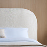 close up image on white boucle headboard of bed