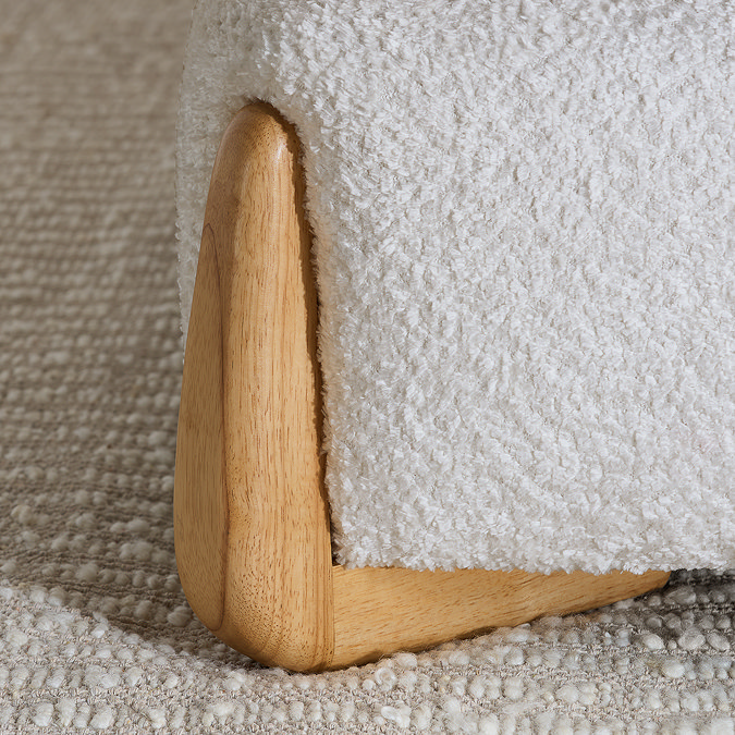 close up on curved light wood legs of bed