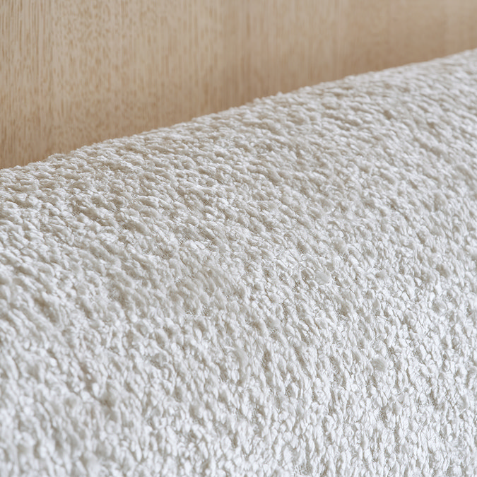 super close up image of boucle material of white curved headboard