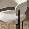 close up image of cream chenille dining chair with tall black legs