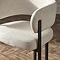 close up image of cream chenille dining chair with tall black legs