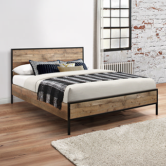 image of wood effect and black metal bed in industrial style bedroom with exposed brick wall