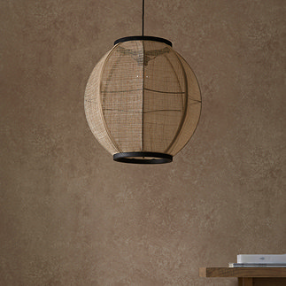 image of circular boho style pendant light shade with black cable, hanging in front of warm brown wall