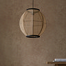 image of circular boho style pendant light shade with black cable, hanging in front of warm brown wall