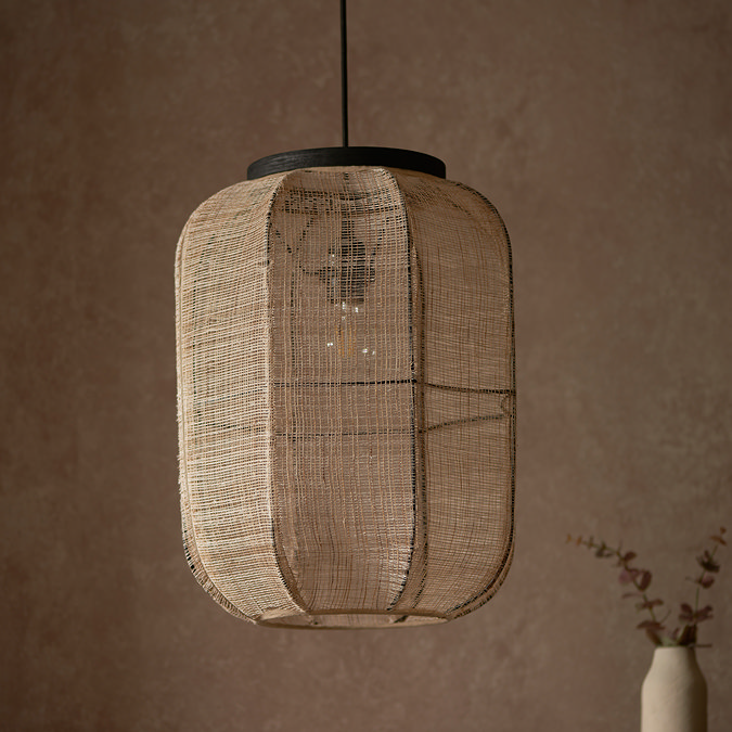 close up image of rectangular linen pendant light with black fixture in front of warm brown wall