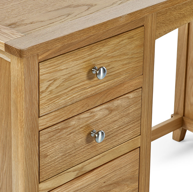 close up on wooden drawers with round metal handles of solid wood dressing table