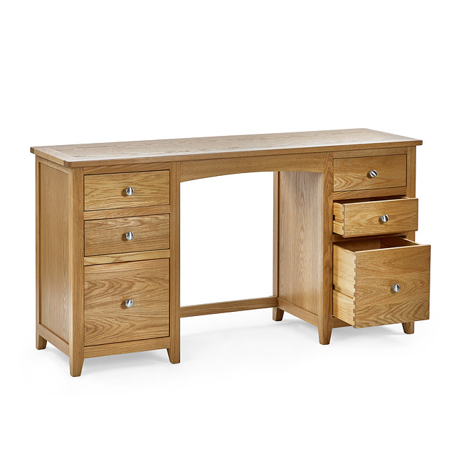 image cut out on white background of solid oak dressing table with six drawers, bottom right one open to indicate storage space