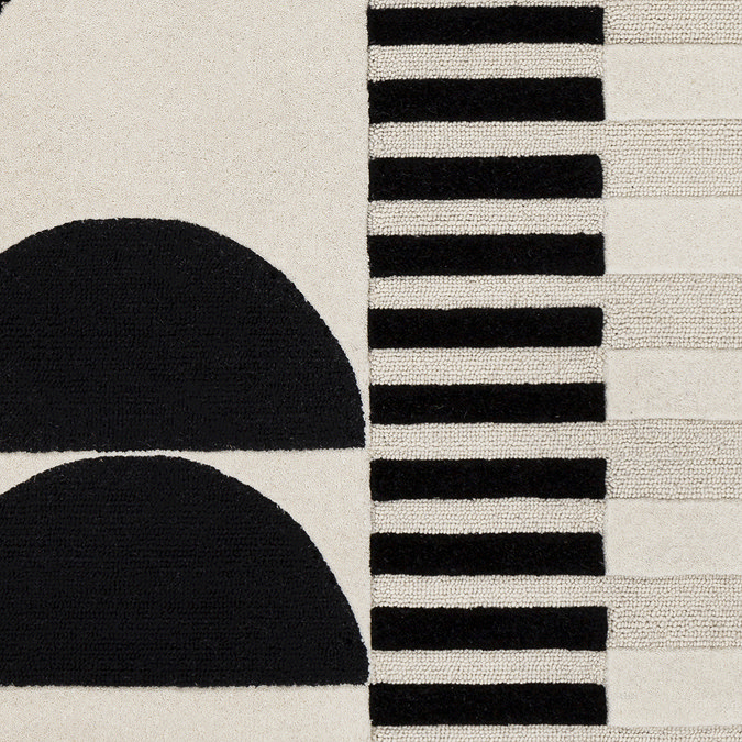 close up swatch image of cream rug with black geometric shapes, focus on colours and textures