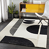 image of cream and black geometric rug on grey wood flooring of home office, in front of bright yellow modern cupboard and potted plant