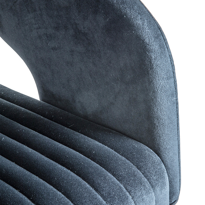 close up on curved arm of black velvet swivel chair, in different lighting to show blue tones of the material