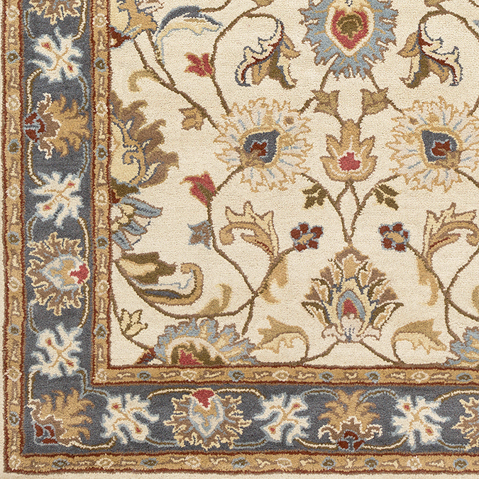 close up swatch image of tan coloured rug with blue flower border