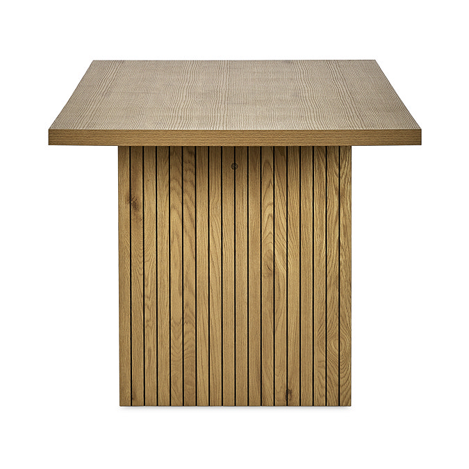 side on image cut out on white background of rectangular oak dining table with fluted rectangular pillar legs, focus on wooden grain fluted detail