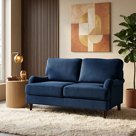 image of 2 seater navy blue sofa on plush rug with dark wood legs