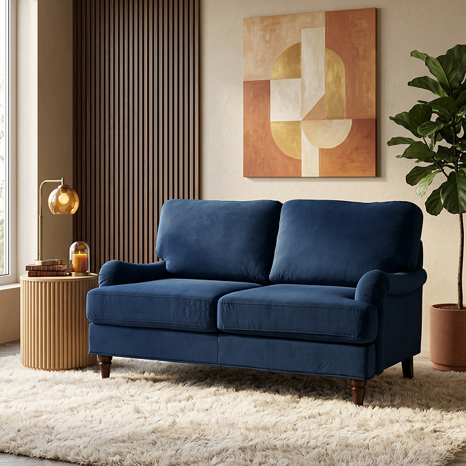 image of 2 seater navy blue sofa on plush rug with dark wood legs
