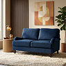 image of 2 seater navy blue sofa on plush rug with dark wood legs