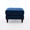 side on cut out image of navy blue pouffe with dark wood legs